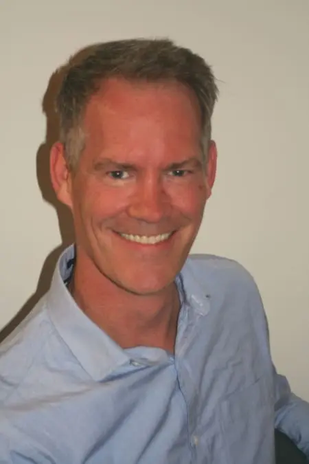 A man with short hair and a blue shirt