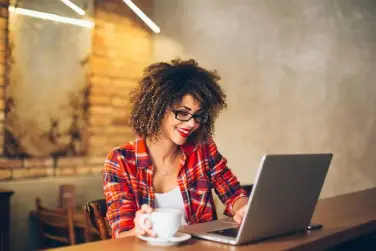 A woman sitting at a table with a laptop.