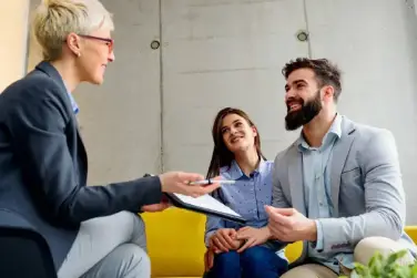 A woman is talking to two men in front of her.
