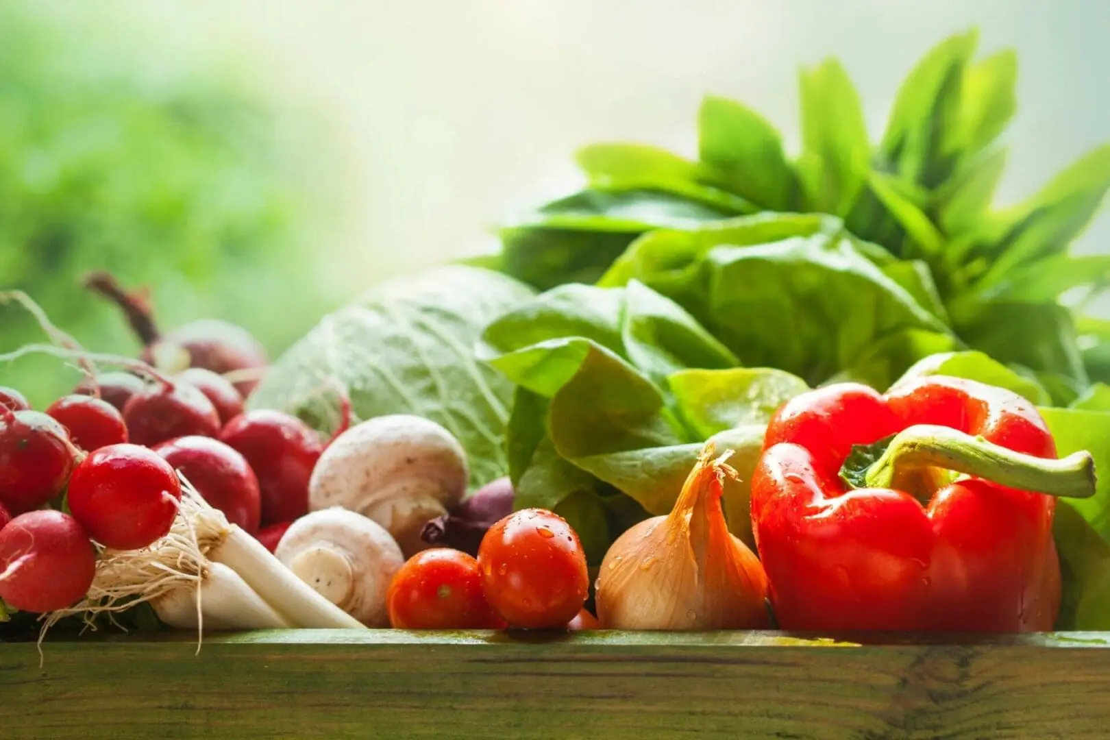 A wooden table topped with lots of vegetables.