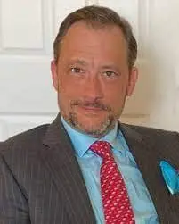 A man in a suit and tie standing next to a door.