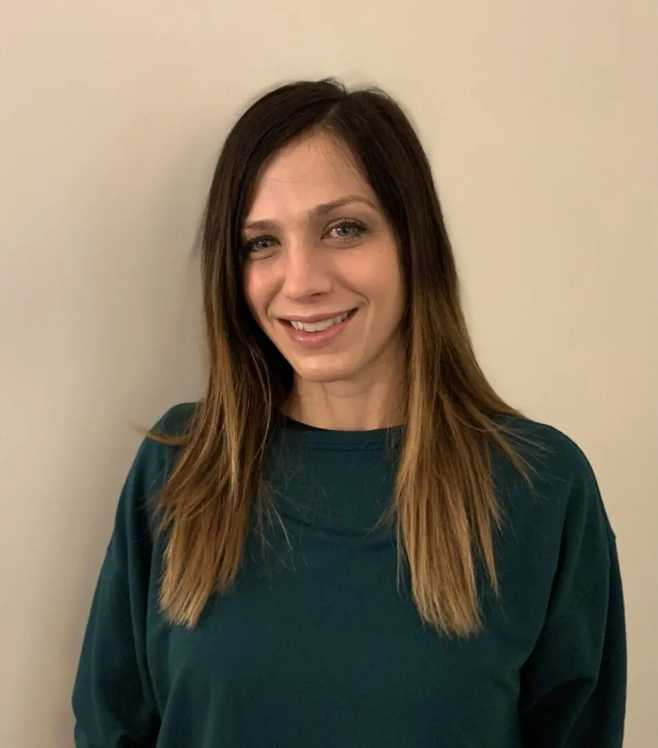 A woman standing in front of a wall.