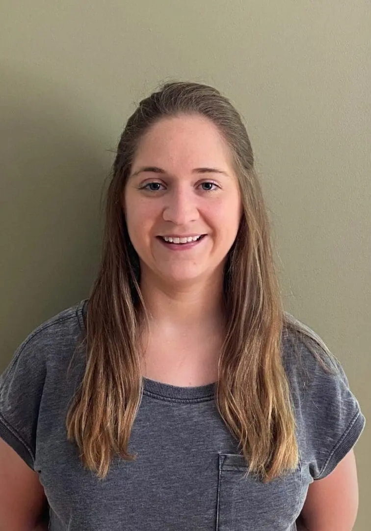 A woman with long hair is smiling for the camera.