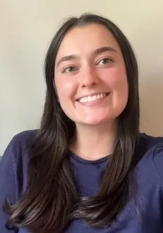 Smiling person with long dark hair.